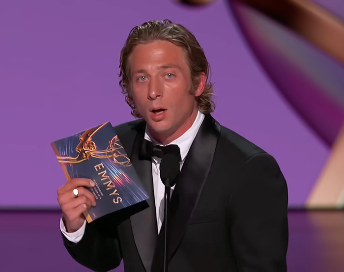 Jeremy Allen White in tuxedo holding an Emmy envelope on stage, highlighting awkward awards show moments.