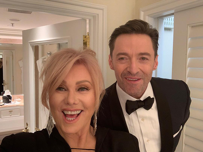 Deborra-Lee Furness posing with ex-husband Hugh Jackman indoors wearing formal outfits.