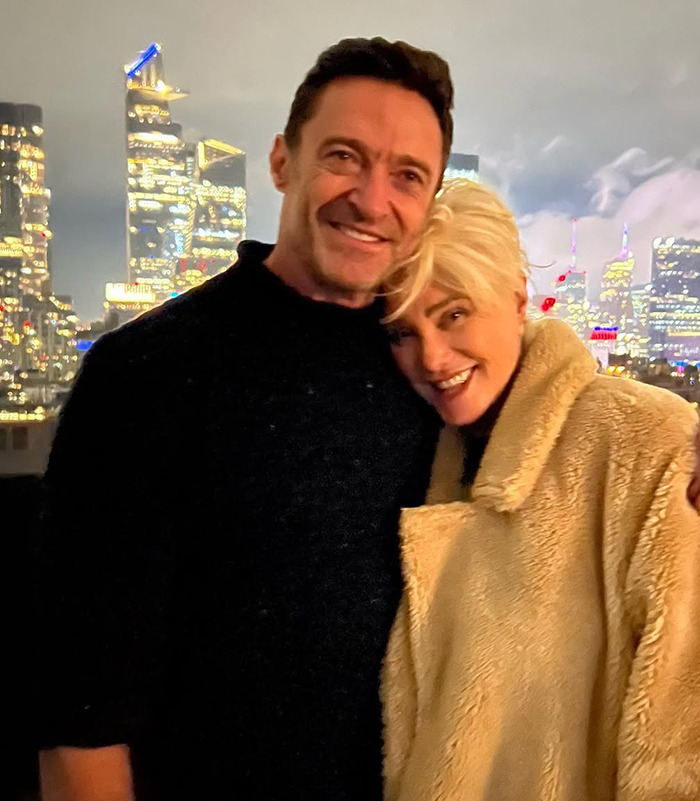 Deborra-Lee Furness and Hugh Jackman embraces against a city skyline at night.