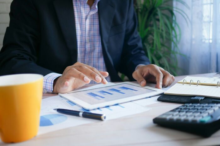 Person analyzing charts on a tablet at a desk, representing high-paying remote jobs.