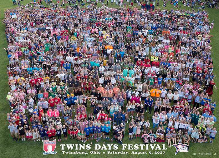 Large group of twins gathered at Twins Days Festival in Twinsburg, Ohio, showcasing the impact of environment on appearance.