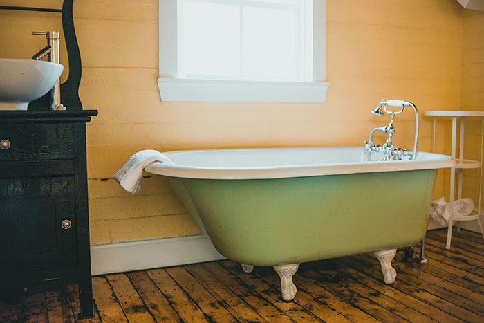 Elegant hotel bathroom with vintage bathtub and rustic decor.