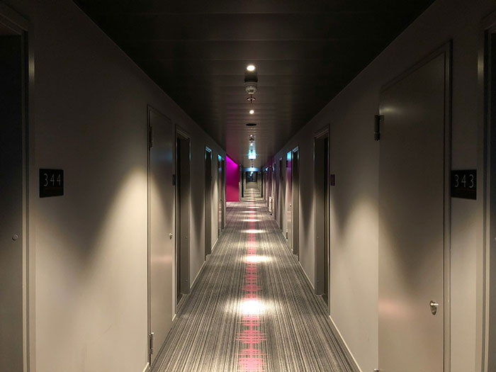 Hotel hallway with numbered doors, showcasing common design elements and layout often seen in accommodations.
