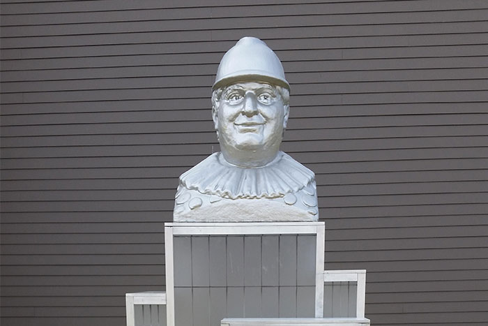 Bust statue against a striped wall, connected to urban legends theme.