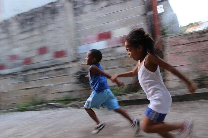 Children playing and running in an urban setting, embodying an urban legend moment.