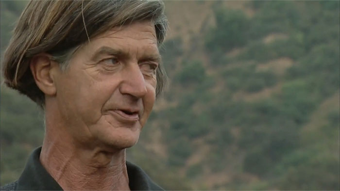 A person outdoors with hills in the background, related to urban legends.