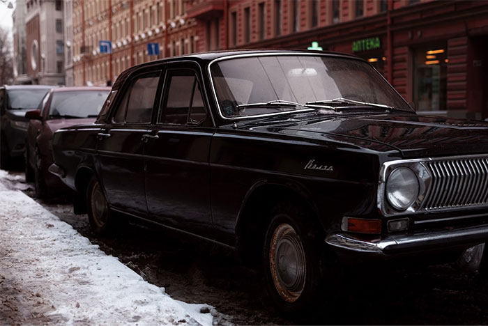 Classic black Volga car parked on a snowy urban street, highlighting urban legends influence on car design.