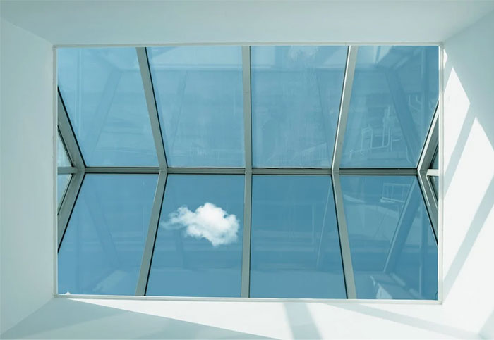 Urban legends reflected on a glass ceiling with a small cloud visible, symbolizing hidden truths.