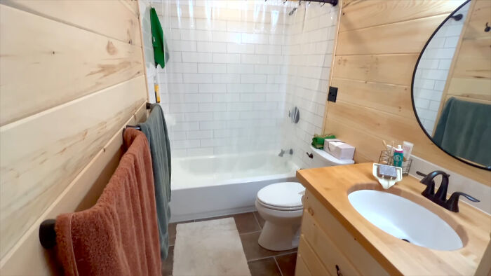 Bathroom in off-grid yurt with wooden walls, a sink, and a bathtub, showcasing sustainable living space details. Bathroom in off-grid yurt with wooden walls, a sink, and a bathtub, showcasing sustainable living space details.