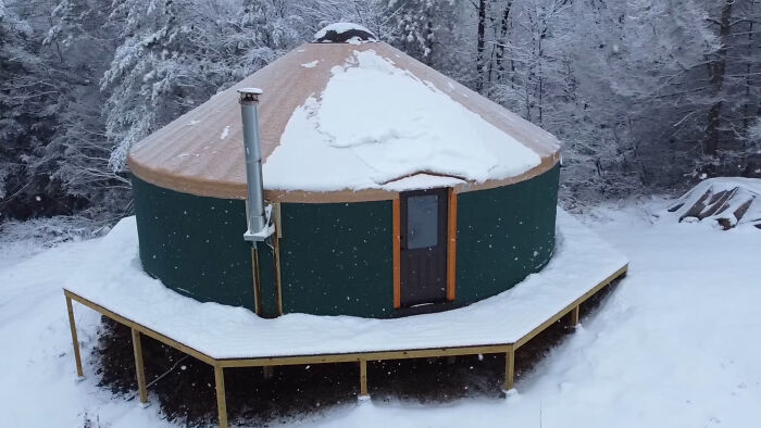 Off-grid yurt built by a couple in a snowy forest setting. Off-grid yurt built by a couple in a snowy forest setting.