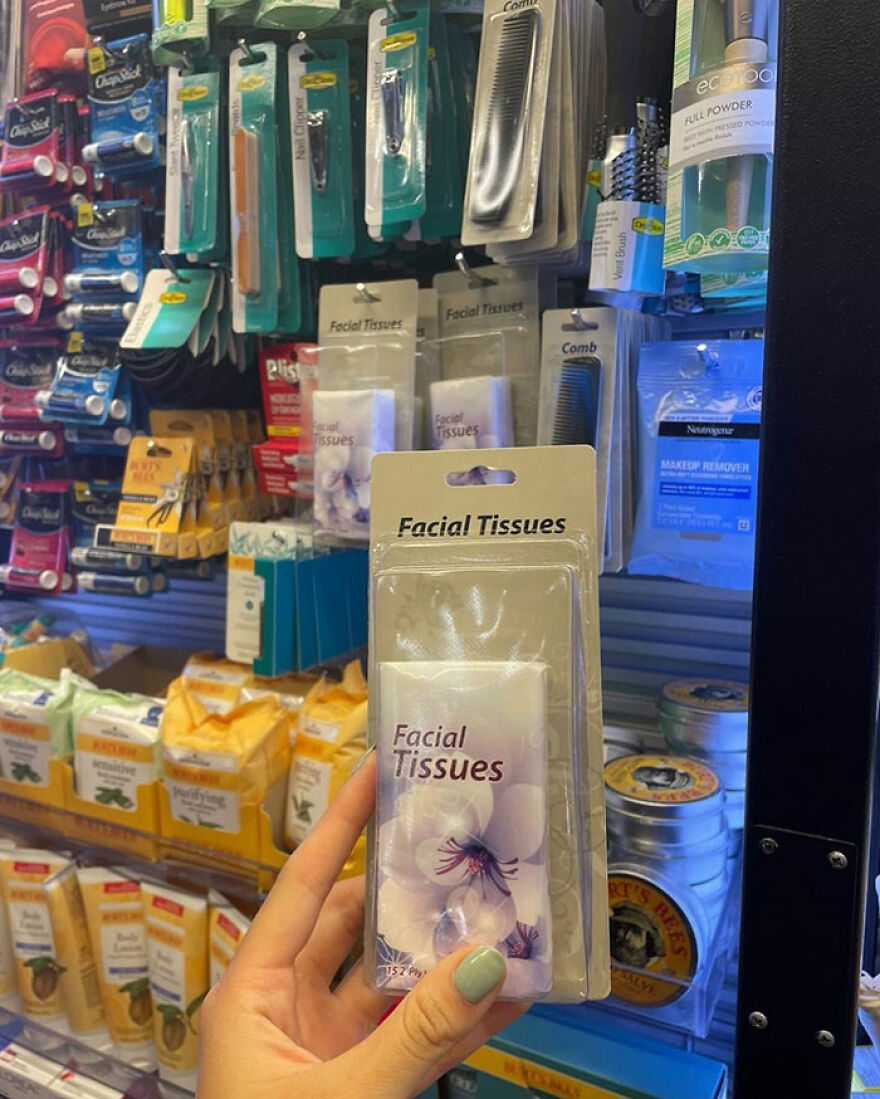 Facial tissues in excessive packaging held in a store aisle, highlighting wasteful unnecessary packaging.