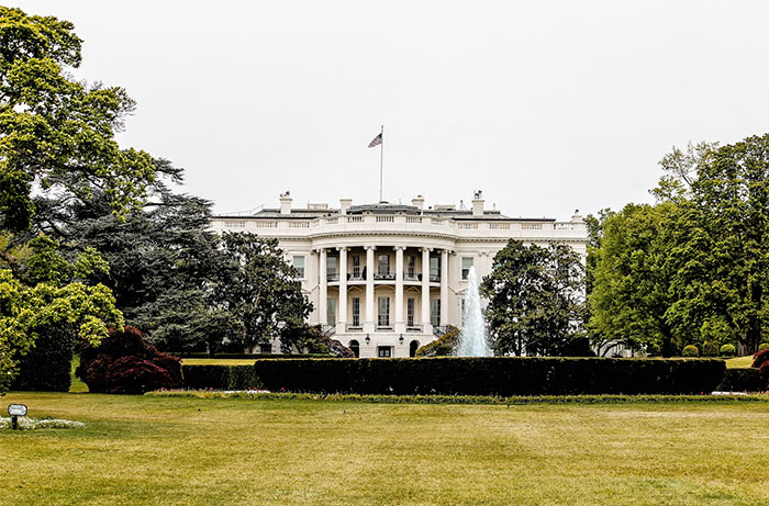 White House exterior with lush green gardens, an iconic symbol related to the wealthy lifestyle.