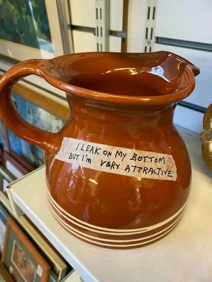 A quirky, funny pottery jug with a note that reads, "I leak on my bottom but I'm very attractive."