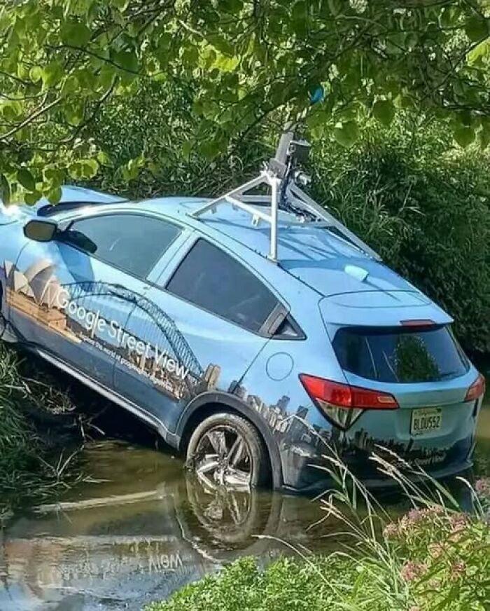 Google Street View car stuck in a creek, showcasing a bizarre and funny scene captured in a natural setting.