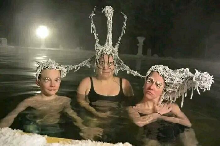 People in a pool with bizarre frozen hairstyles, creating a funny scene.