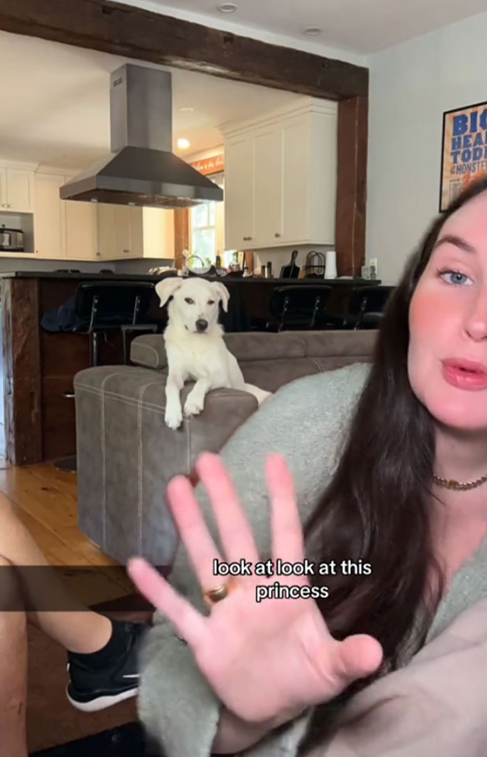 Woman with a dog named Pearl on a couch, discussing the name in a cozy living room.