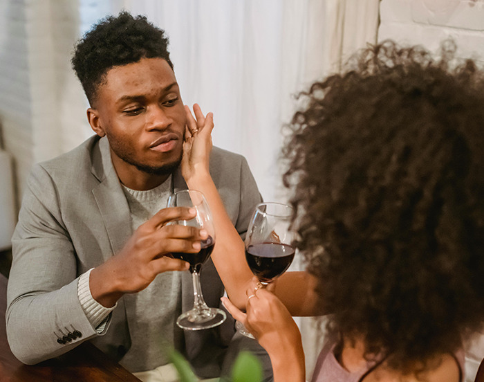 Man and woman on a date, sharing wine and a moment of connection, illustrating dating experiences.