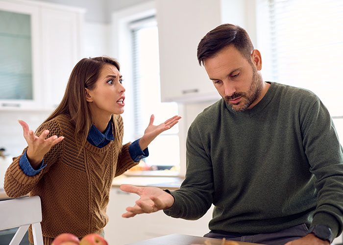 Man and woman arguing at home, highlighting divorce and custody conflict.
