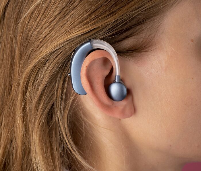 A person wearing a hearing aid, showcasing advanced technology for remote work opportunities.