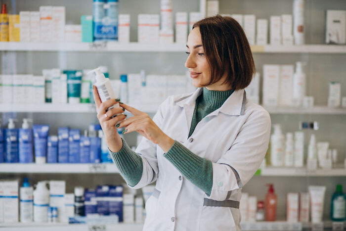 A pharmacist analyzing product labels in a pharmacy, related to high-paying remote jobs.