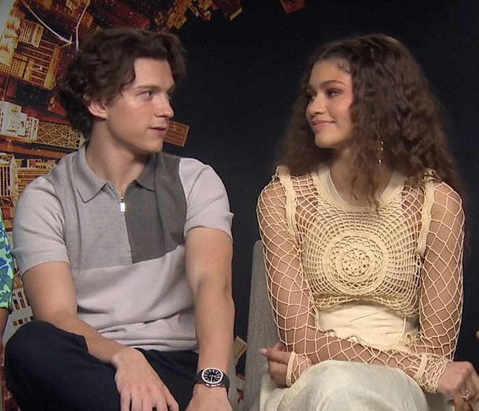 Zendaya and Tom Holland looking at each other during an interview.