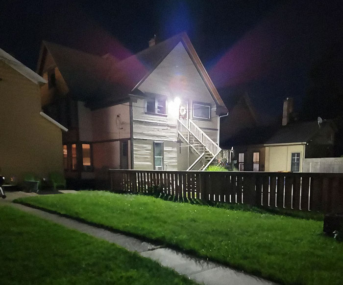House exterior at night with bright light, reflecting neighbor complaints about illumination.