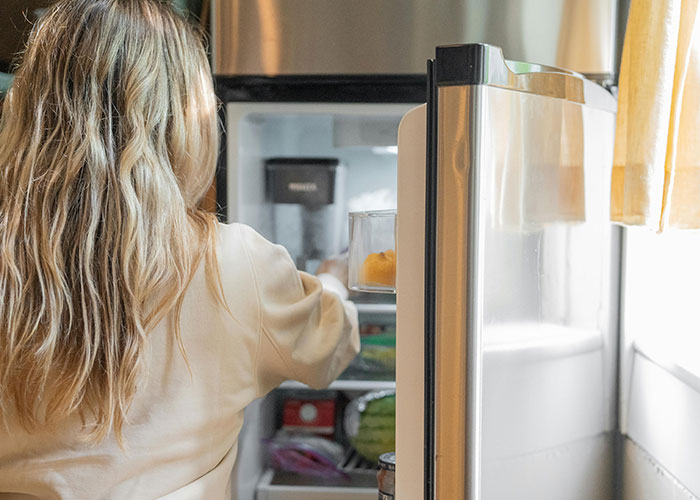 Woman placing lunch in the office fridge as a decoy to prevent food theft.