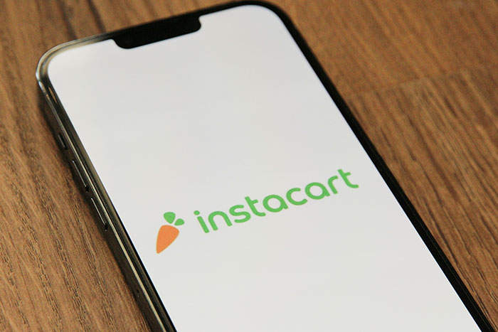 "Instacart app on phone screen, illustrating safe side hustle ideas."
