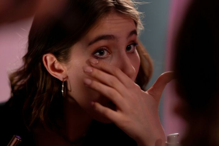 Person applying makeup under eye, illustrating rare cosmetic procedures.