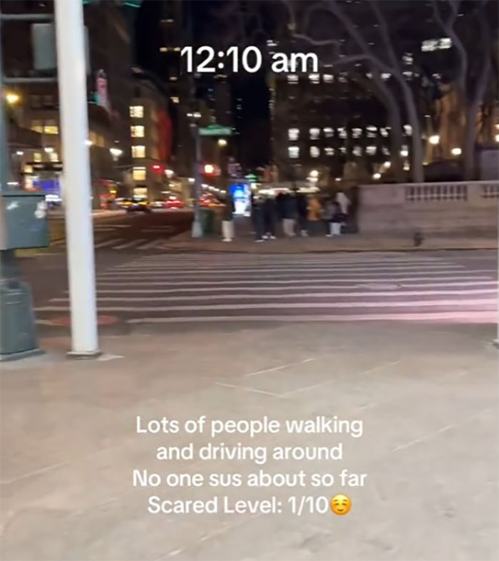 Woman walking in NYC at midnight, rating fear level among busy streets, scared level noted as 1/10.