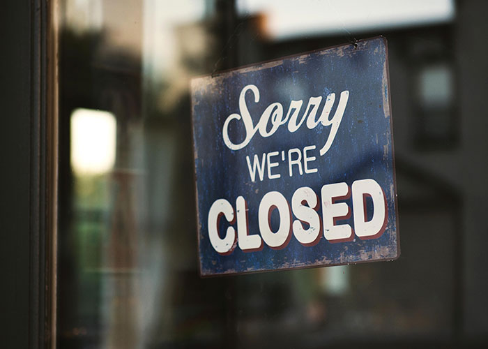 "Sorry, we're closed" sign hanging on a door, reflecting European culture shocks for Americans.