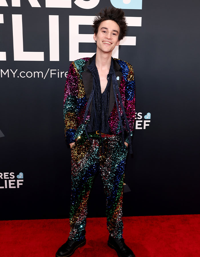 Person in a colorful sequin suit on the red carpet at the 2025 Grammys, showcasing a unique fashion choice.