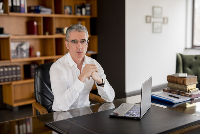 Man in office with laptop and books, related to discussing dumbest rumors.