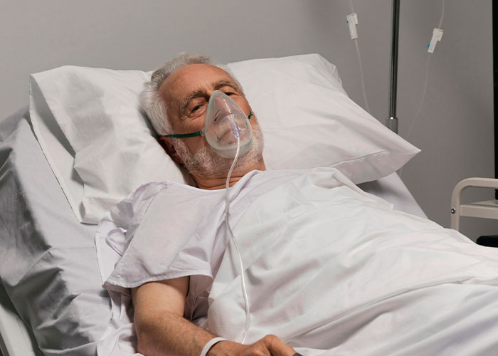 Elderly man in hospital bed with oxygen mask, highlighting heartfelt last moments.