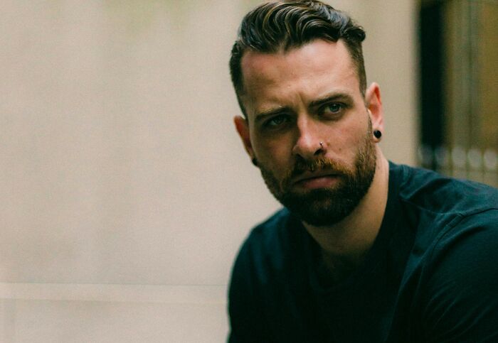 Man with a nose piercing and beard, representing unusual cosmetic procedures in modern style.