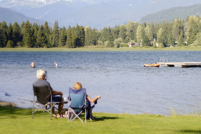Personas relajándose junto al lago en un día soleado.