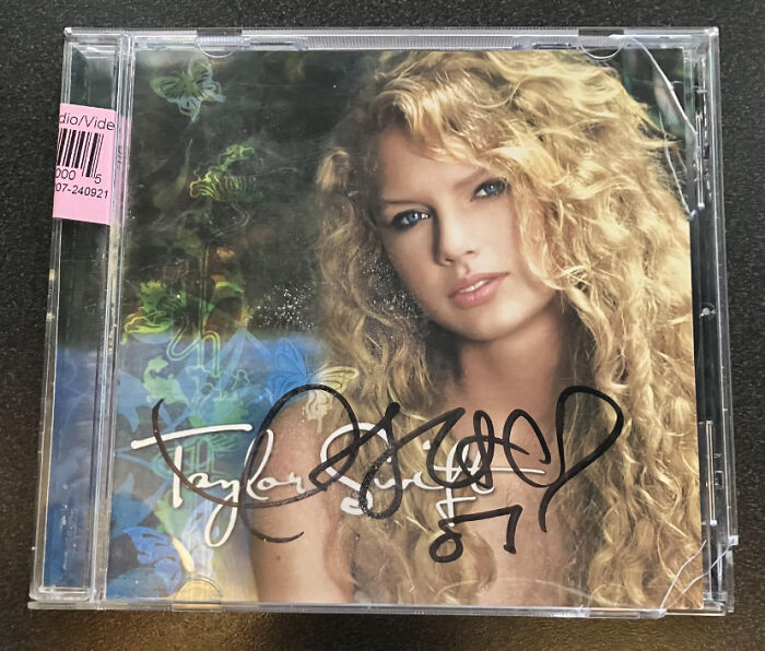 Signed CD of a popular artist found thrifting, featuring a cover with a woman with curly hair in a clear case.
