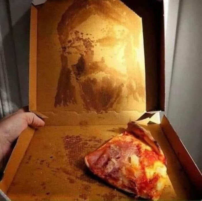 Pizza box with grease marks resembling a face, showcasing a weird image worth seeing.