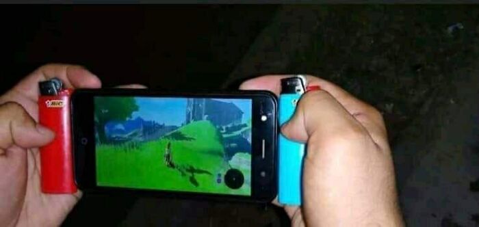 Hands holding a phone with lighters mimicking a gaming console, showcasing weird creativity.
