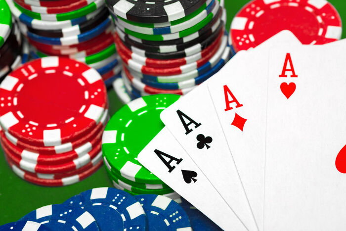 Poker chips and four aces on a table, illustrating rules implemented for one individual.