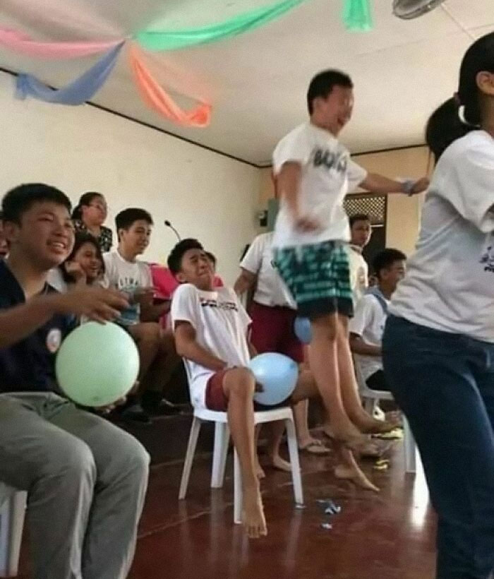 Niños jugando un divertido juego con globos en una reunión, creando una imagen rara y entretenida.