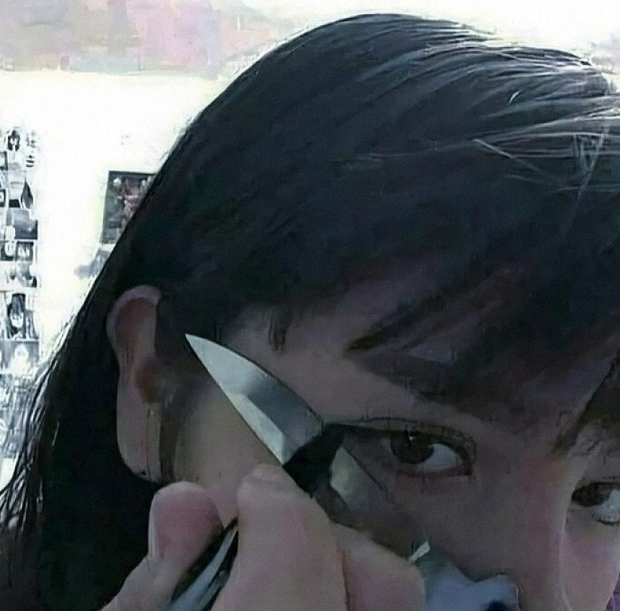 A person holding a knife near their eye, creating a dramatic and weird effect worth seeing.