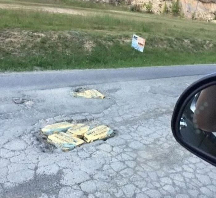 Huecos en la carretera llenos de bolsas de cemento en una escena rara.