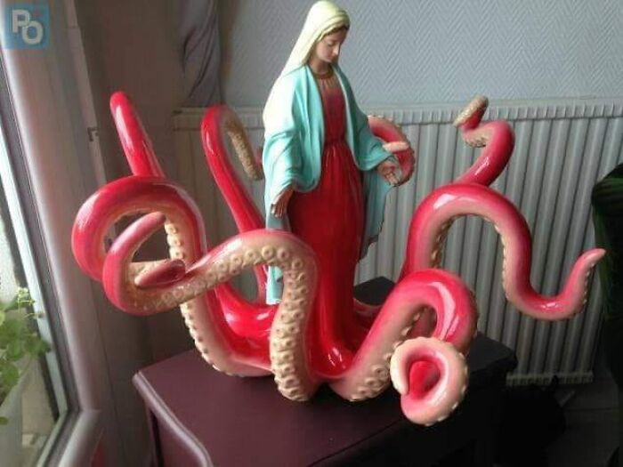 Statue of a figure with octopus tentacles, a weird image blending religious iconography and sea creature motifs.