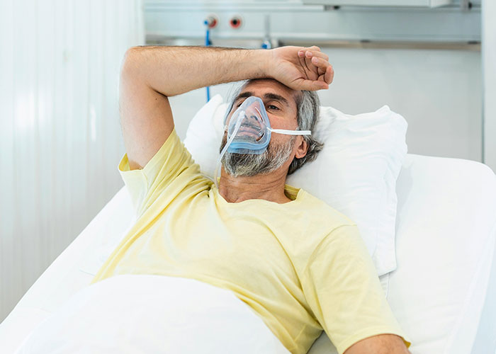 Elderly man in hospital bed with an oxygen mask, depicting heartfelt moments from dying patients.