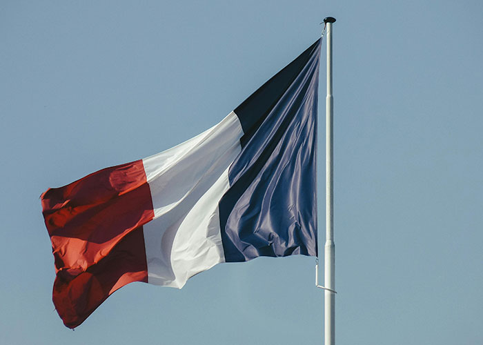 French flag waving, representing Europe culture shocks experienced by Americans.