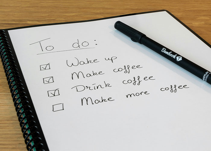 To-do list featuring whimsical tasks like making coffee, with a pen on the side.