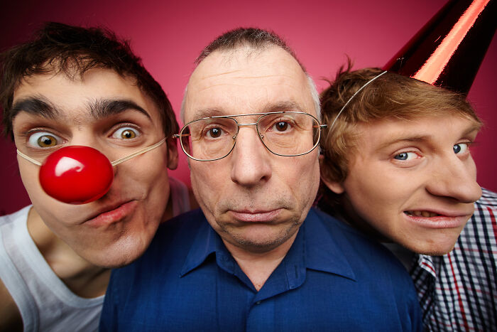 Three adult people making funny faces against a pink background, highlighting harsh life lessons.