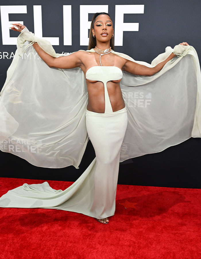 Woman in unique white gown on 2025 Grammys red carpet displaying bold fashion choice.