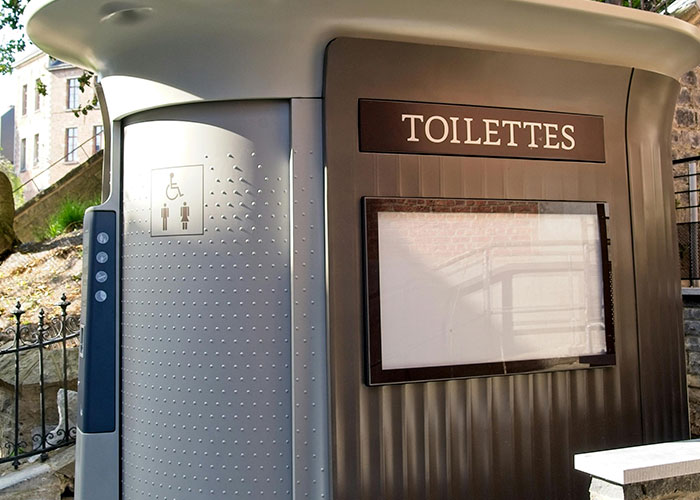 Modern public restroom with a "Toilettes" sign, showcasing a European amenity that may surprise Americans culturally.